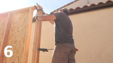 Fixation provisoire du premier montant du demi-mur M2 avec le panneau du mur M1